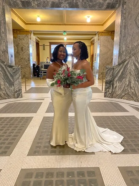 Newlywed couple standing together inside the marble courthouse hall
